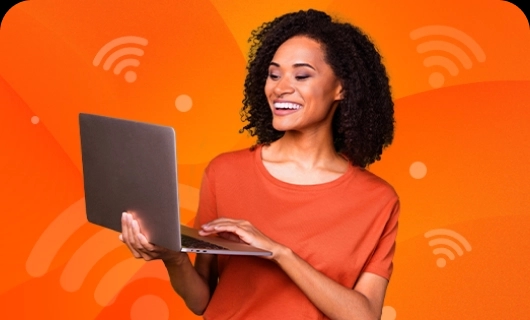 Uma mulher rindo e olhando para um notebook