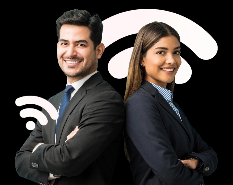 Um homem e uma mulher estão lado a lado, de costas um para o outro, ambos sorrindo. O homem tem cabelos escuros e curtos, veste um terno preto com gravata azul e camisa branca. A mulher tem cabelos castanhos compridos, usa um blazer preto, camisa listrada azul e branca. Ambos têm uma postura confiante, com os braços cruzados, parecendo profissionais em um ambiente de trabalho formal.
